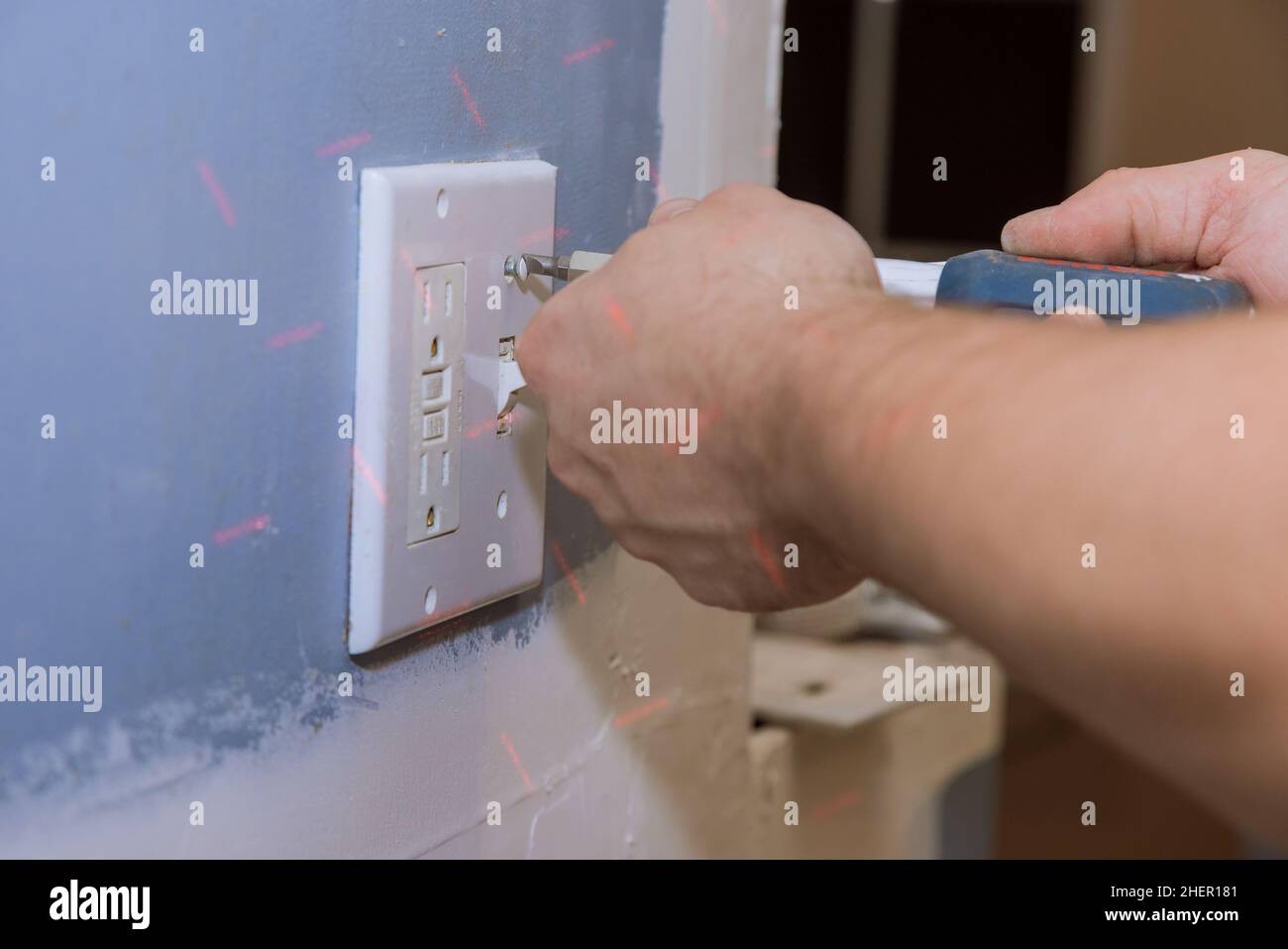 Removing white light switch cover plastic on preparation wall for new paint  wall Stock Photo - Alamy