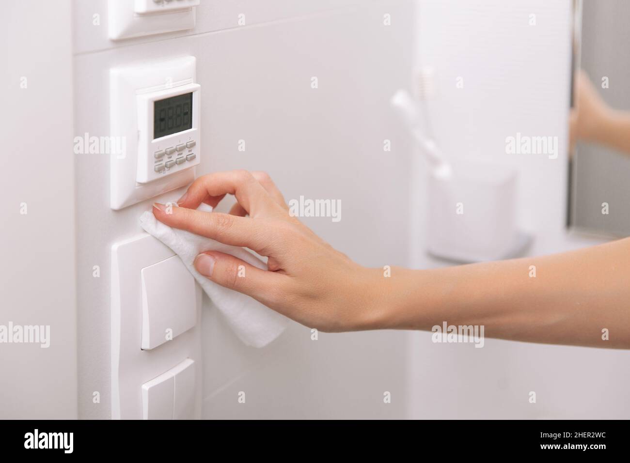 Cleaning switches and sockets with a microfiber cloth. Woman hand using