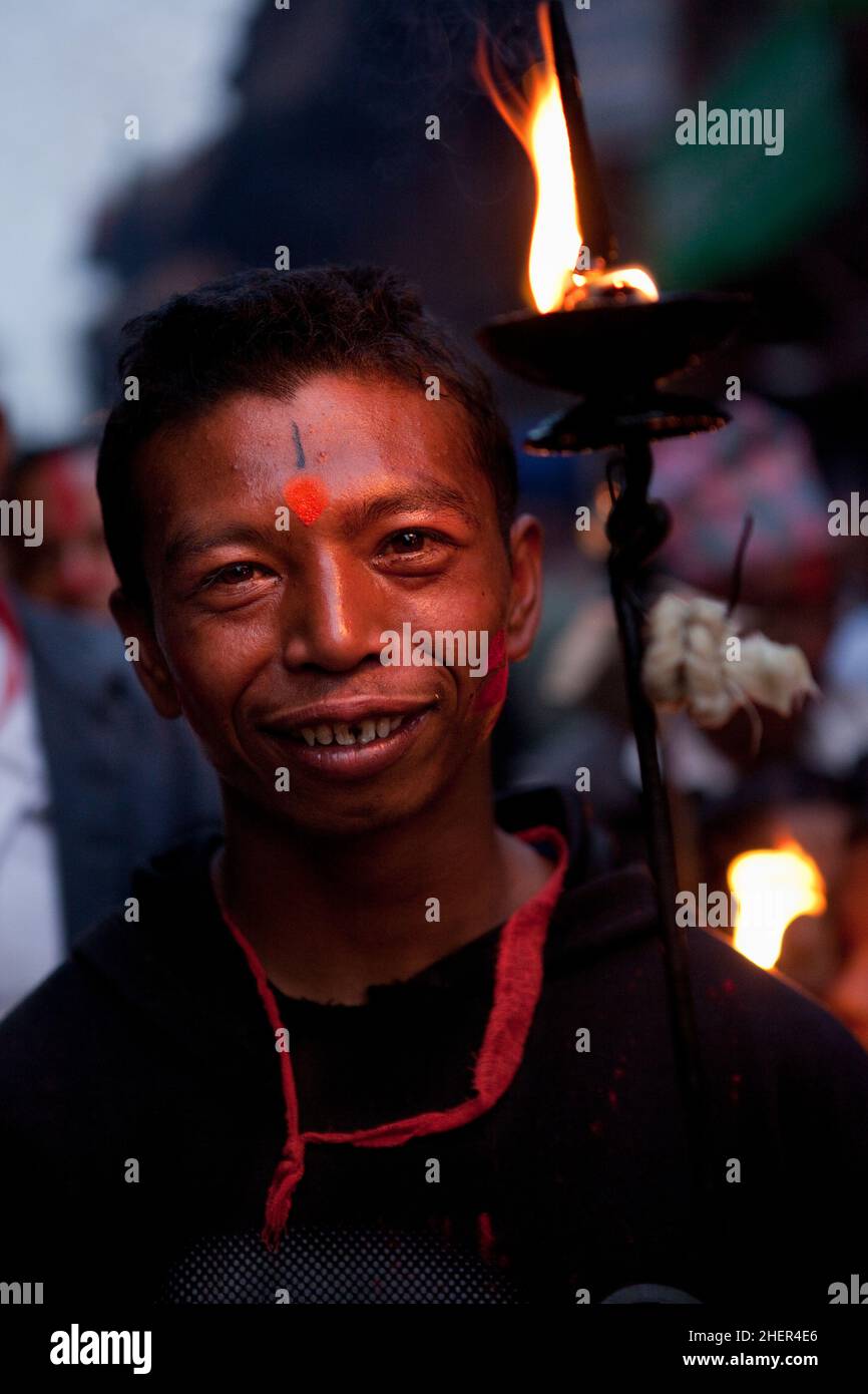 A torch bearer during Brahmayani Jatra in Bhaktapur's Dattatreya Square during Nepali New Year festivities. Stock Photo