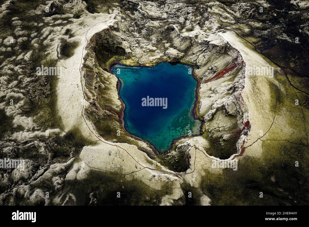 Aerial capture of Tjarnigigur an intense blue crater lake. Stock Photo