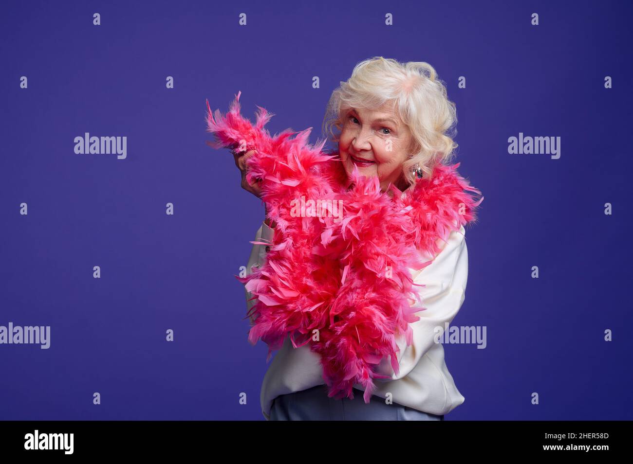 Energetic elegant woman with a feather boa on her shoulder Stock Photo