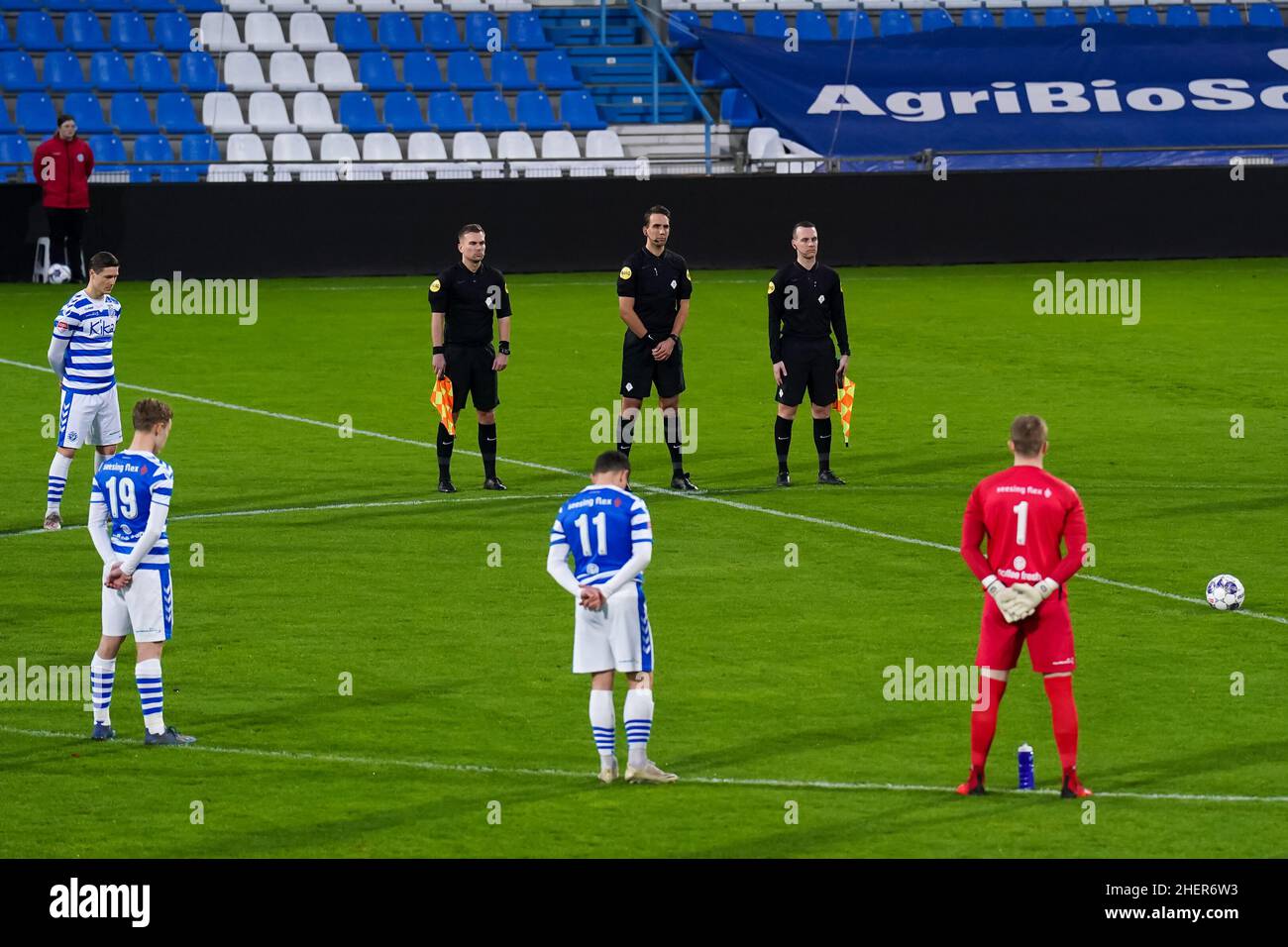 DOETINCHEM, NETHERLANDS - JANUARY 9: Assistant referee Jordi Been, Referee Clay Ruperti, Assistant referee Yorick Weterings and the teams of De Graafschap and VVV-Venlo observe a minute of silence ahead of kick-off in memory of all the so called Superboeren who passed away in 2021 during the Dutch Keukenkampioendivisie match between De Graafschap and VVV-Venlo at De Vijverberg on January 9, 2022 in Doetinchem, Netherlands (Photo by Rene Nijhuis/Orange Pictures) Stock Photo