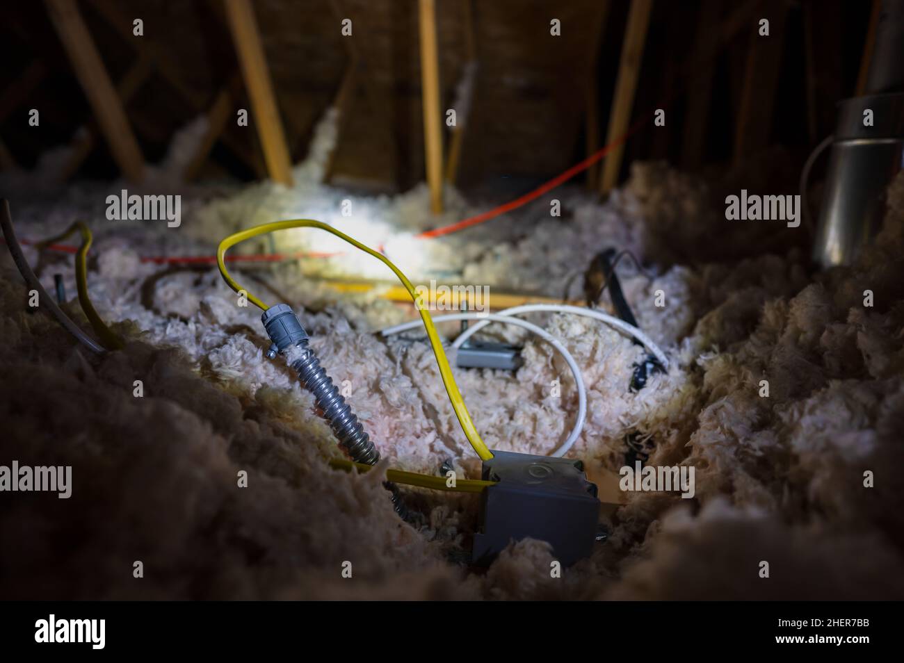 Electrical wire and conduit laying loose on blown insulation in a house attic Stock Photo Alamy