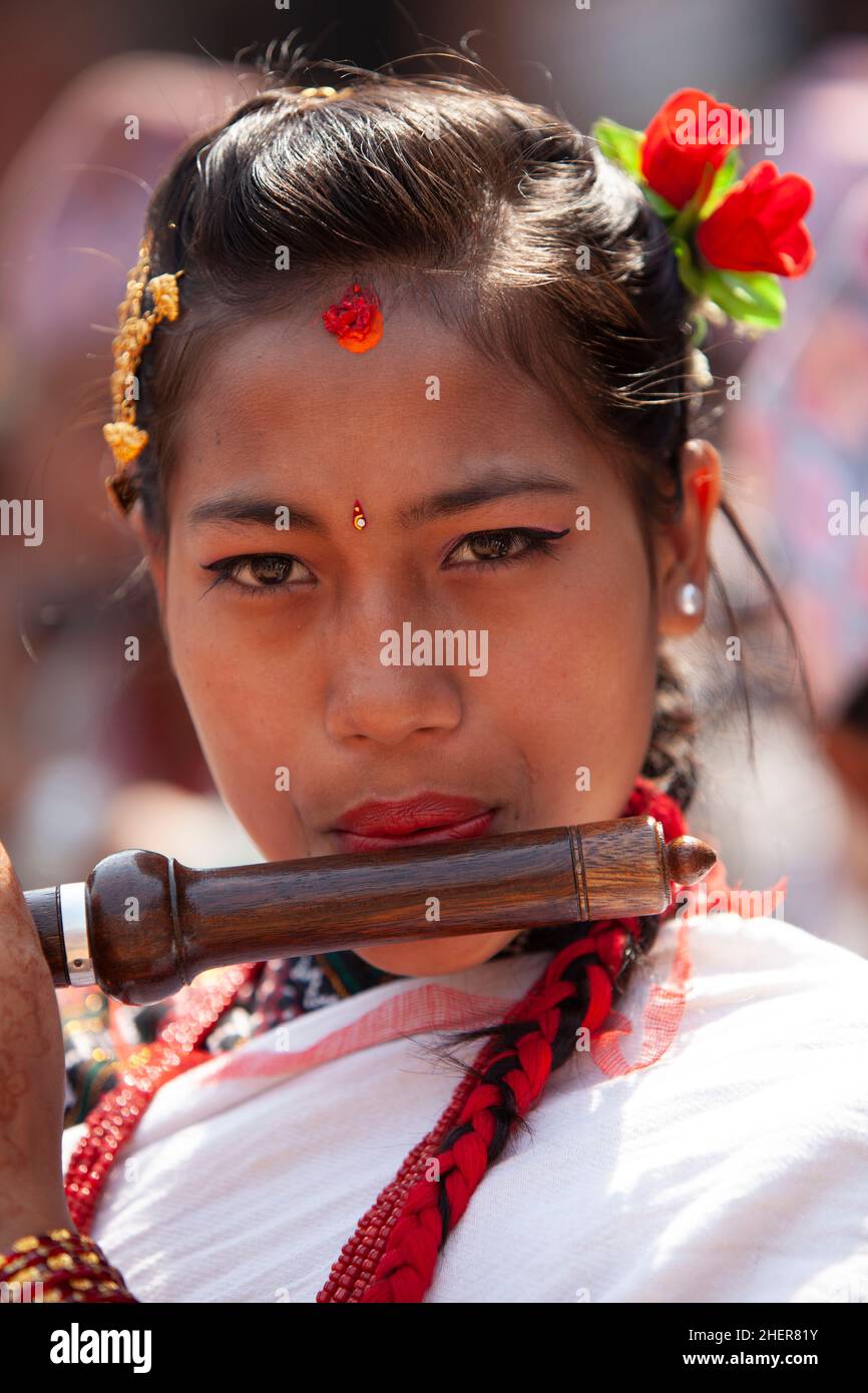 Young female flautist performs during Taa Din, part of Nepali New Year (Bisket Jatra) in the UNESCO World Heritage city of Bhaktapur. Stock Photo