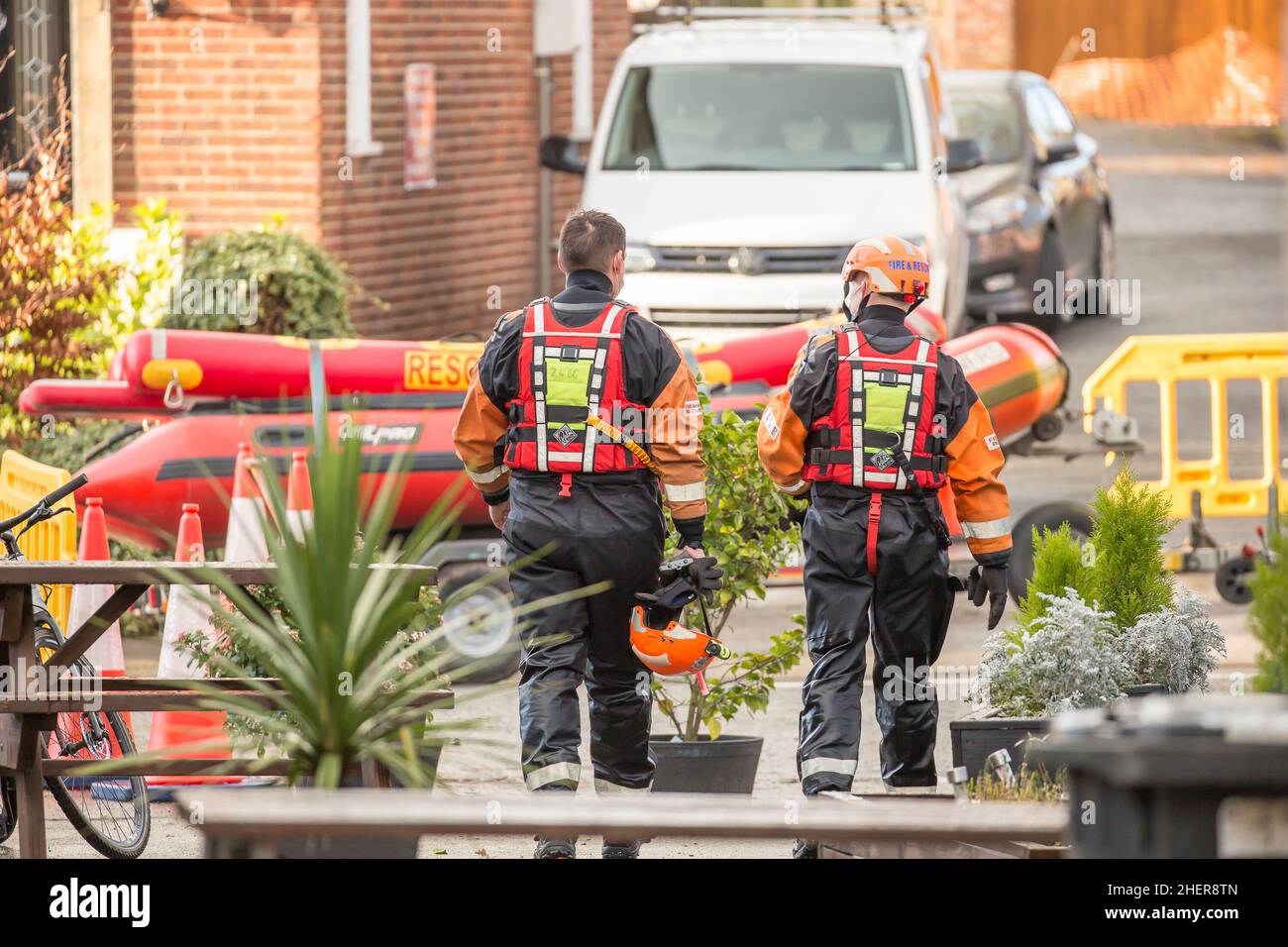 Rear view of on duty fire rescue crew with a rescue boat during Bewdley floods, UK, in January 2021. Stock Photo