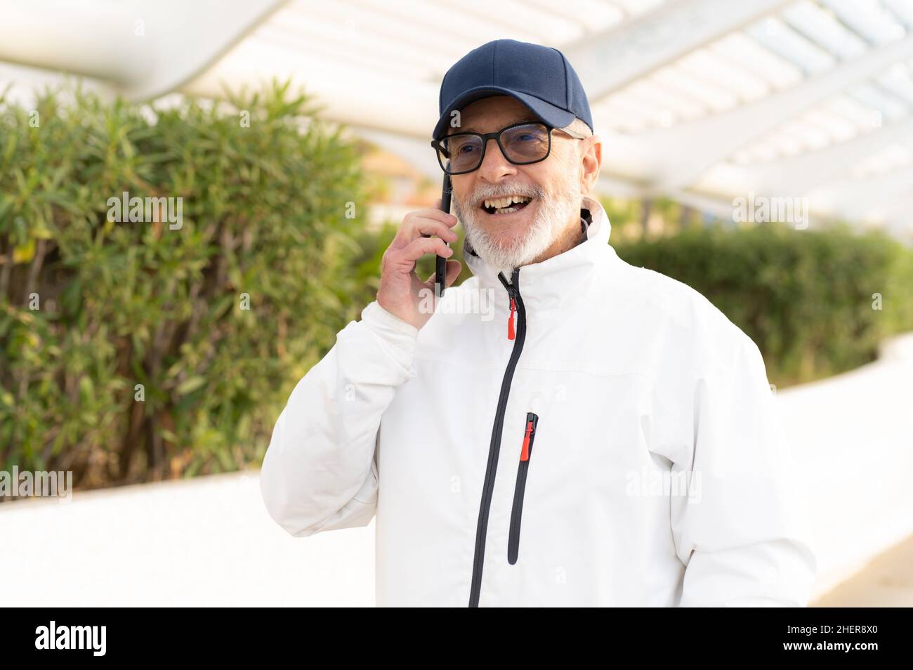 Elderly man talking on smartphone outdoors in the city. Stock Photo