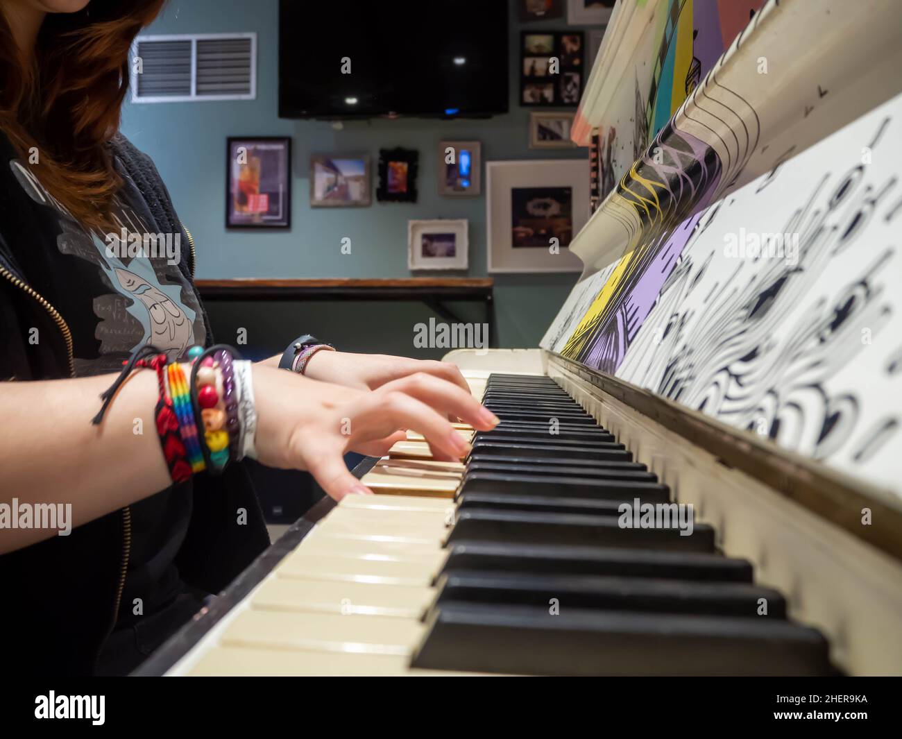 Hands upon the black and white keys of an upright piano Stock Photo