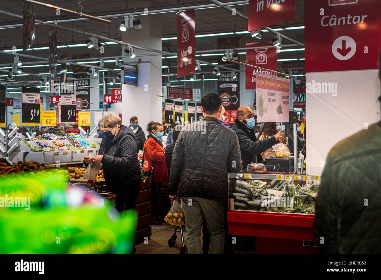 Chisinau, Moldova - October 17, 2021: Inside a supermarket. Men and women wearing medical masks buy vegetables from the self-service section of the Ve Stock Photo