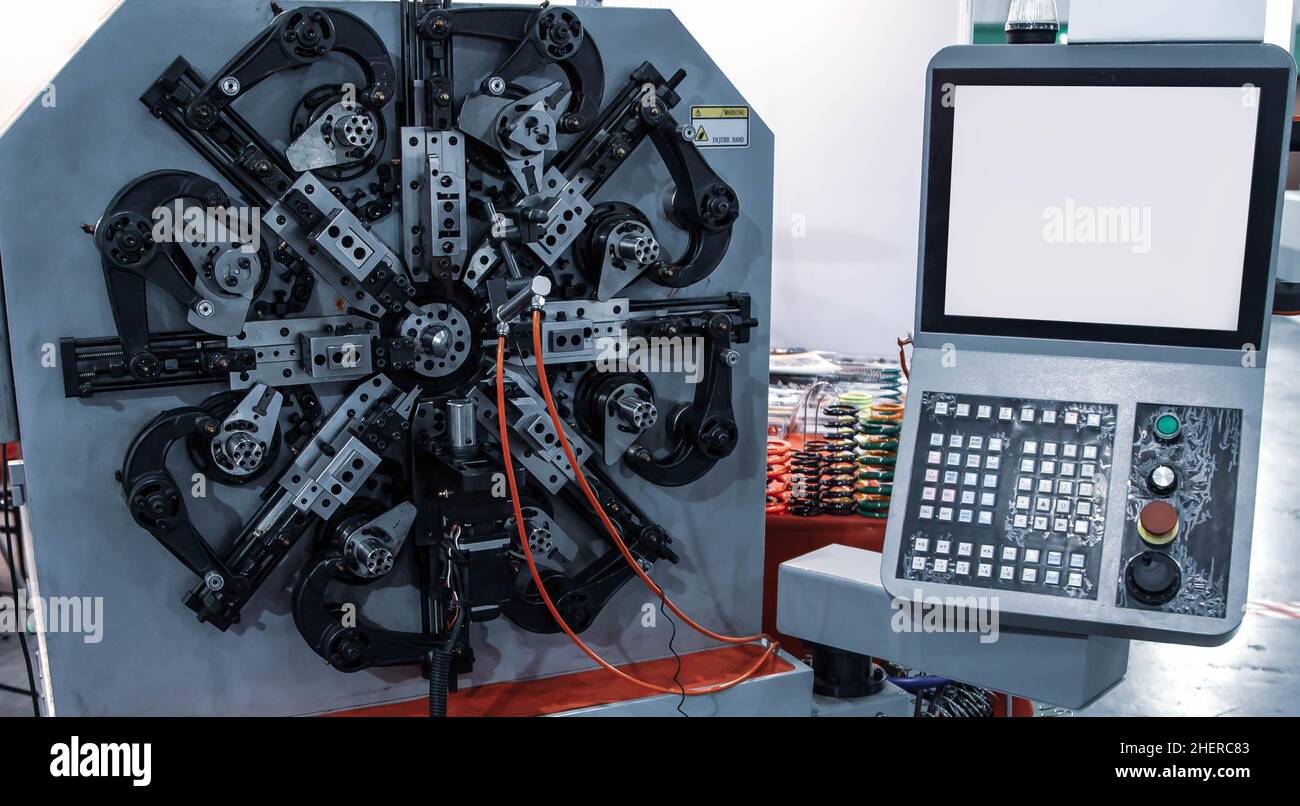 Automated CNC spring coiling machine. Industrial machinery Stock Photo