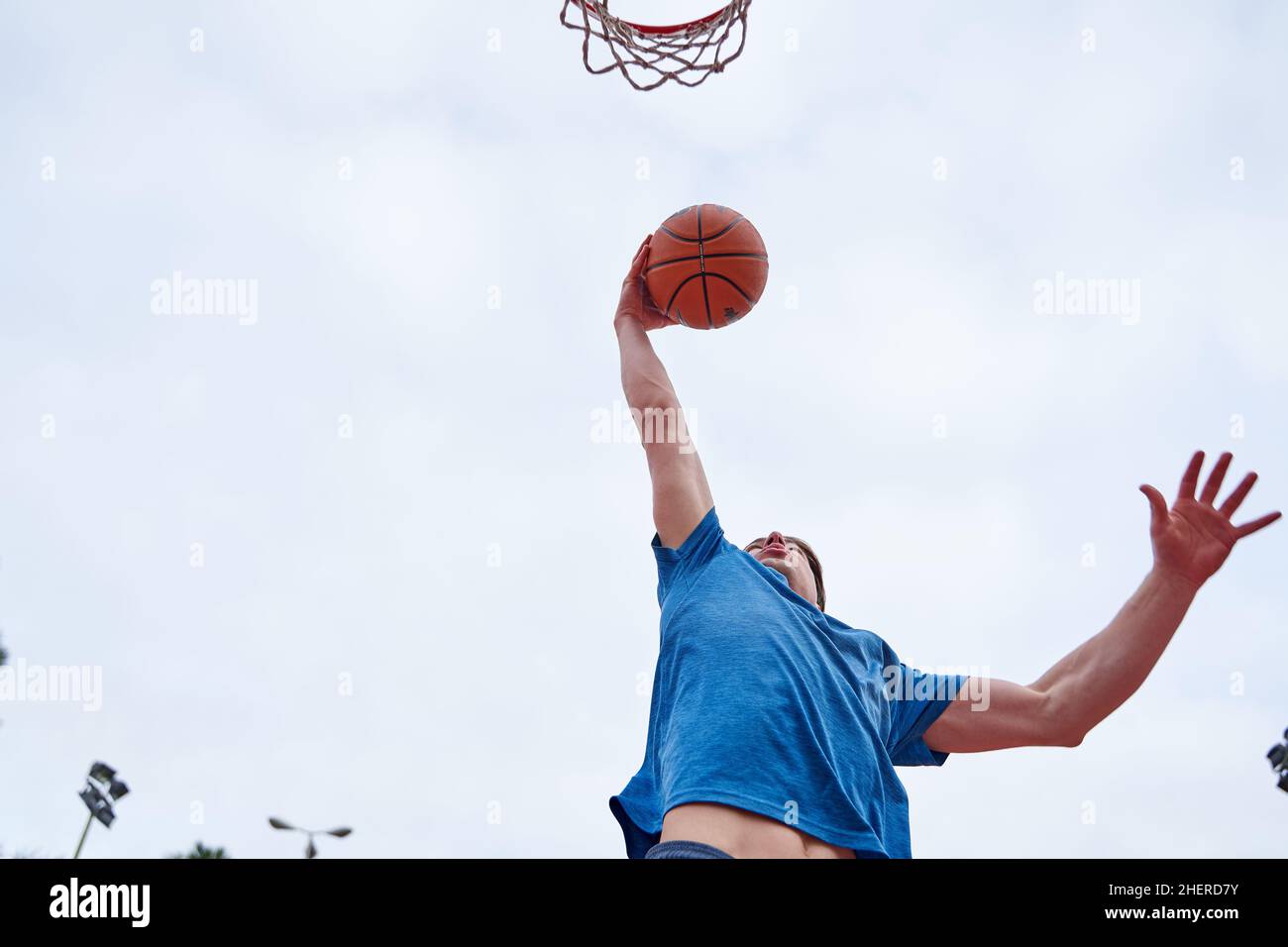 young Caucasian man dunking on an outdoor basketball court. concept of sport Stock Photo