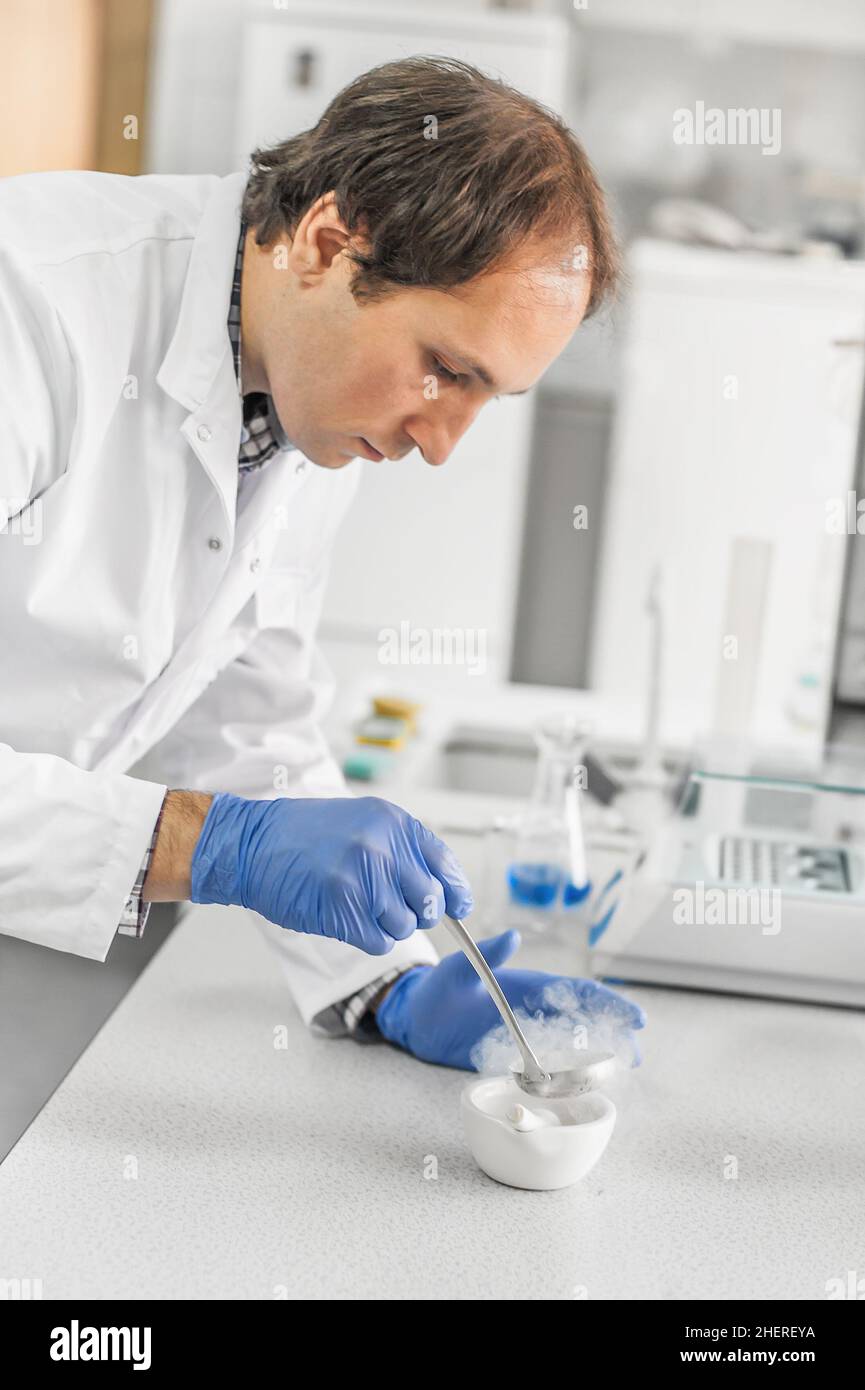 Laboratory technician performs an experiment with liquid nitrogen in
