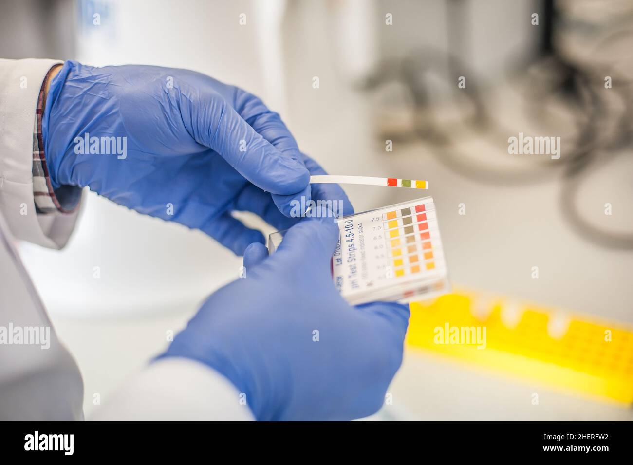 Laboratory technician working with test strips indicator paper in the