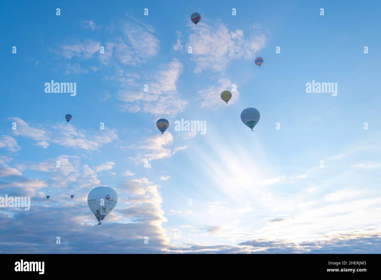 Hot air balloons are flying over fairy chimneys at sunrise in ...