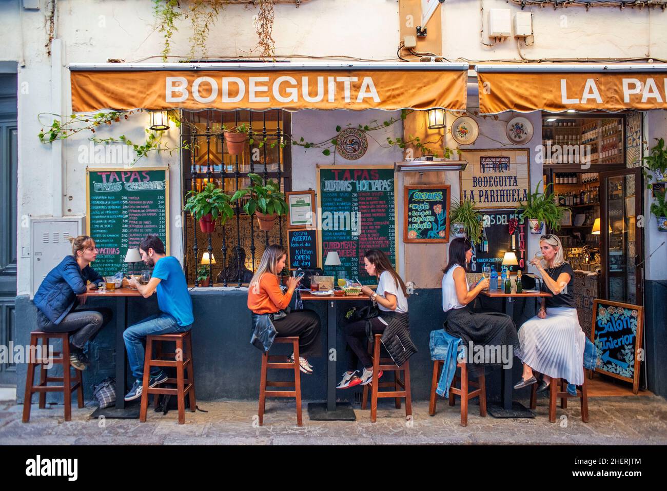 Locals enjoying food in Bodeguita La Parihuela tapas bar in Santa Cruz district Seville Antalusia Spain Stock Photo
