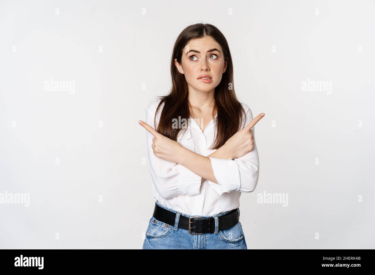 Indecisive adult woman pointing fingers sideways hesitant, making ...