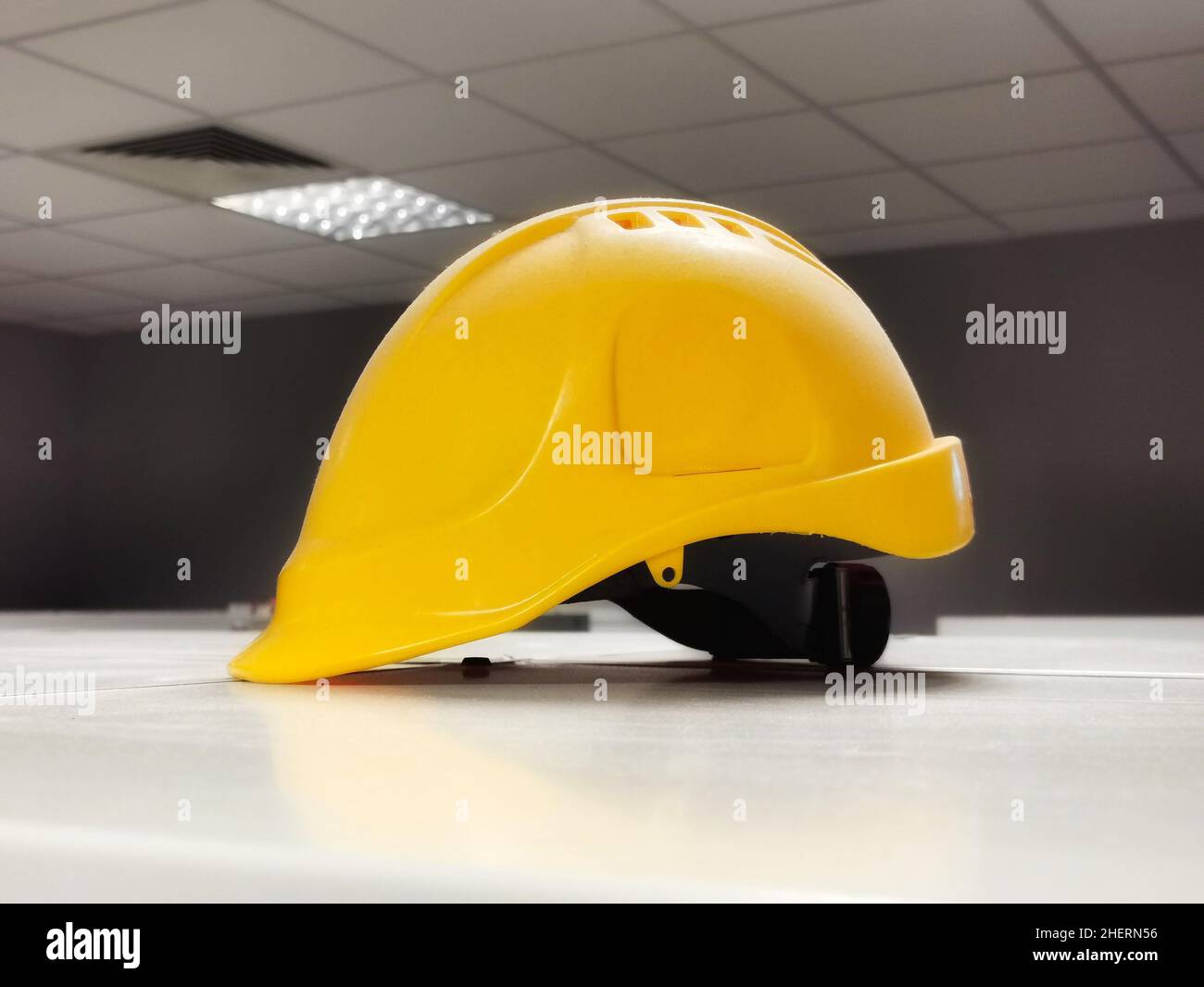 Yellow helmet in the factory dressing room. Safety regulations concept Stock Photo