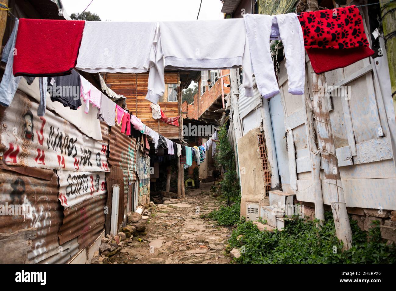 Washing drying in an alleyway amongst deprived shanty town shacks, in notorious gang Barrio Egipto neighborhood, Bogota, Colombia, South America. Stock Photo