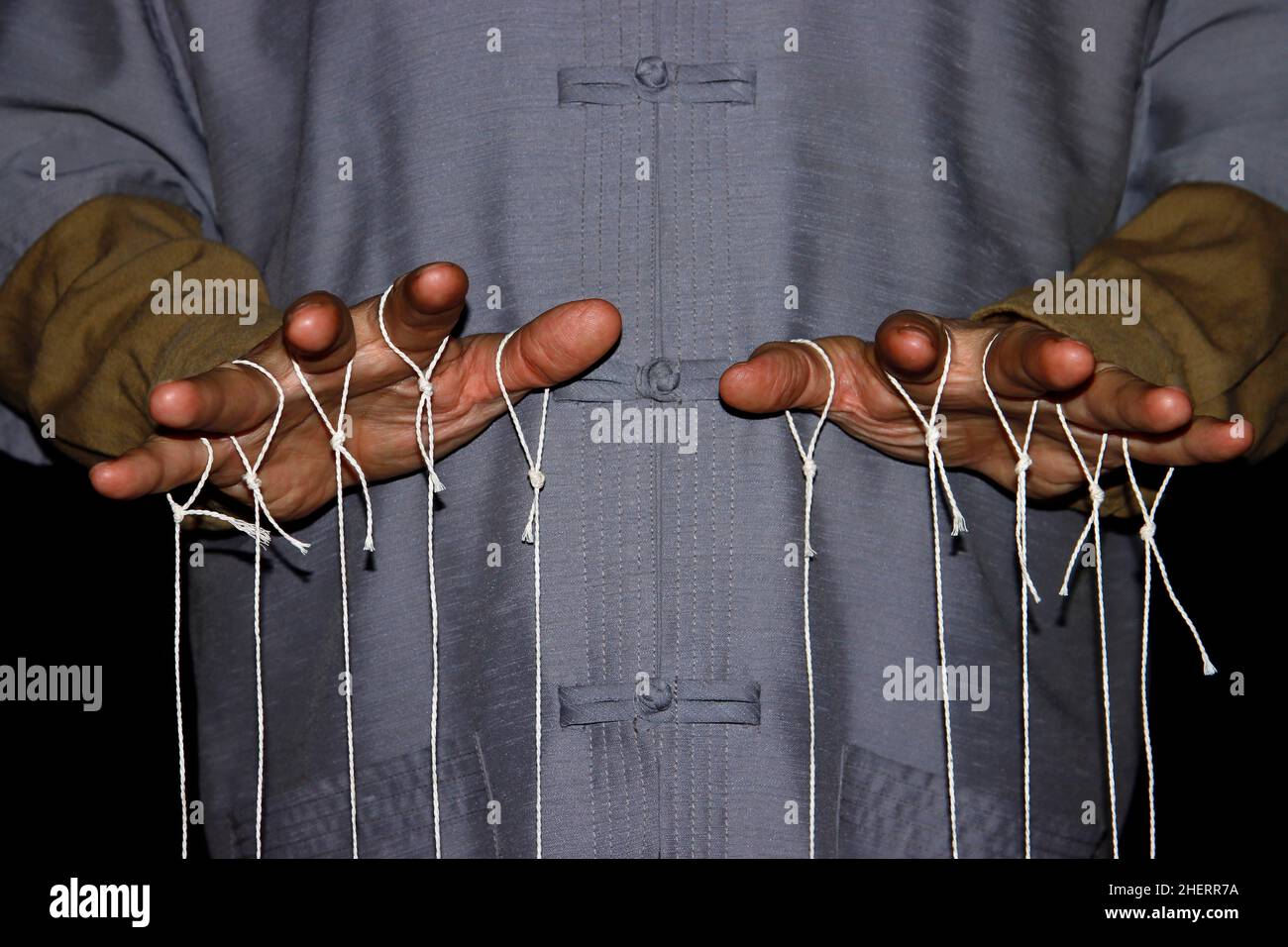 Stringpulling puppeteer with Chinese shirt, studio photography with