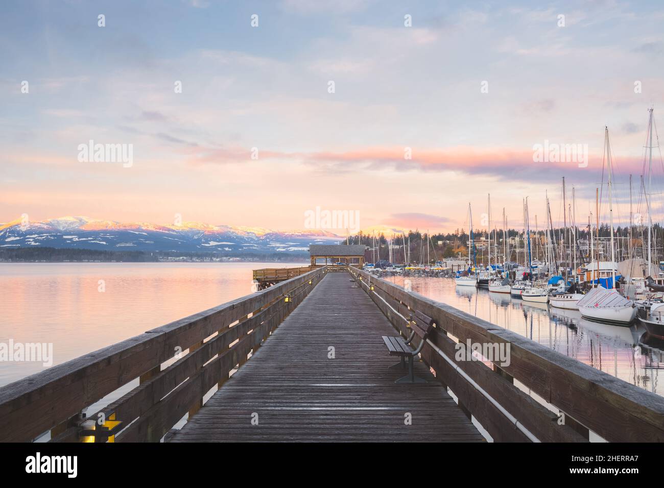 Sunset or sunrise at the waterfront boardwalk and marina on a cold winter day at Comox Harbour, British Columbia, Canada. Stock Photo