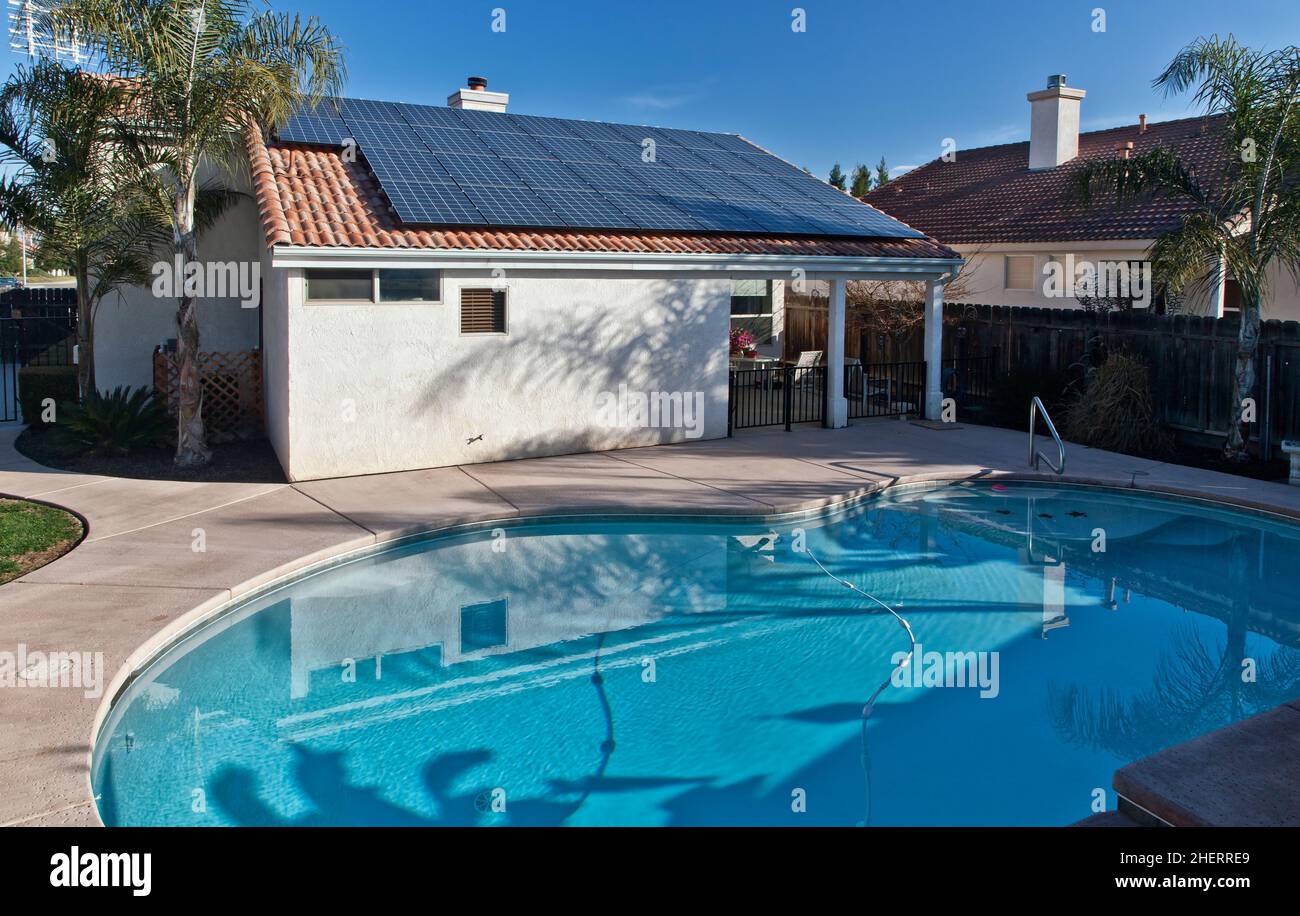 Solar electric panels mounted on residence roof, swimming pool,  California Stock Photo