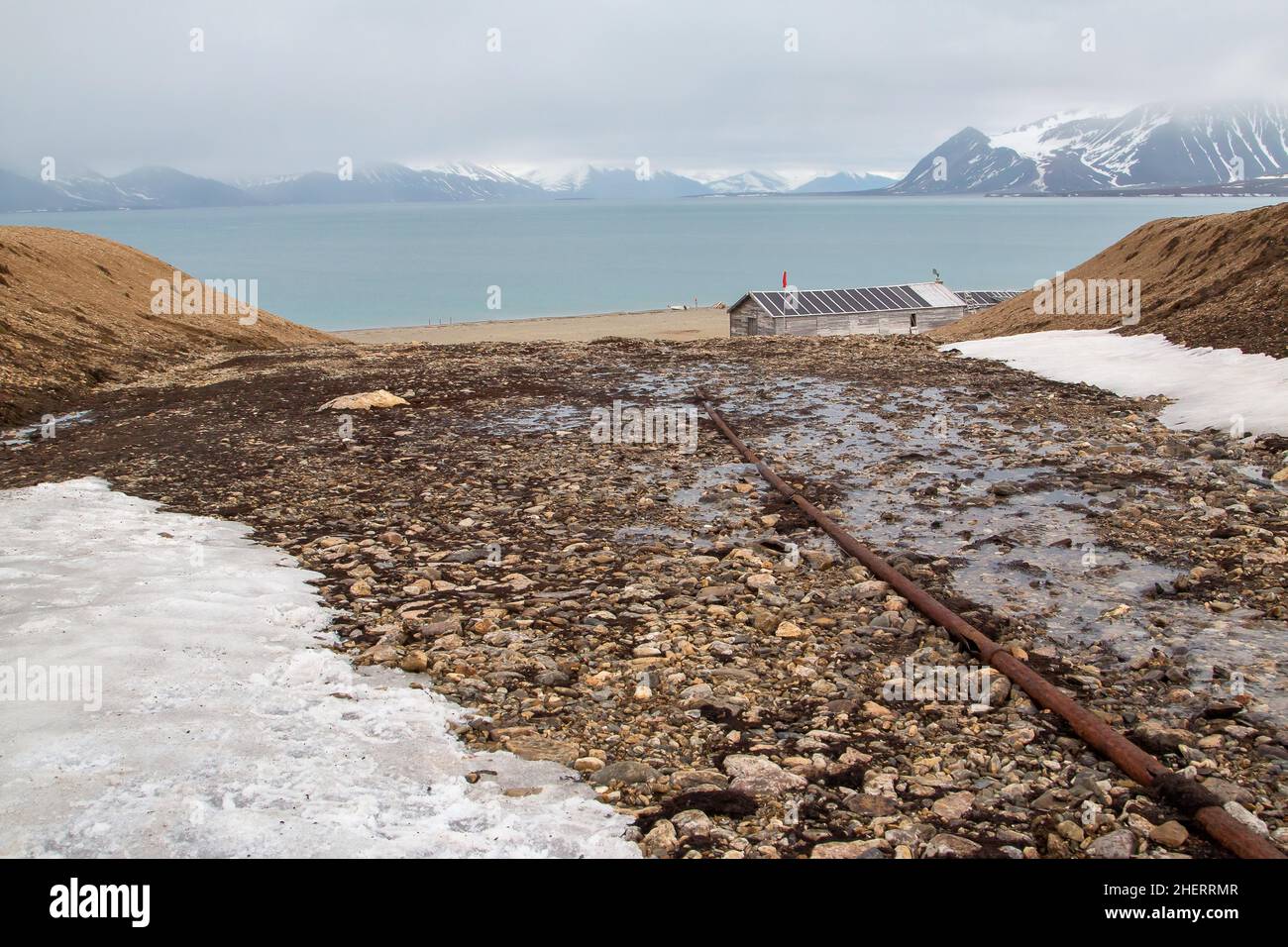 Former mining station Calypsobyen, old pipeline with wooden barrack, view of Bellsund, Spitsbergen Island, Norway Stock Photo