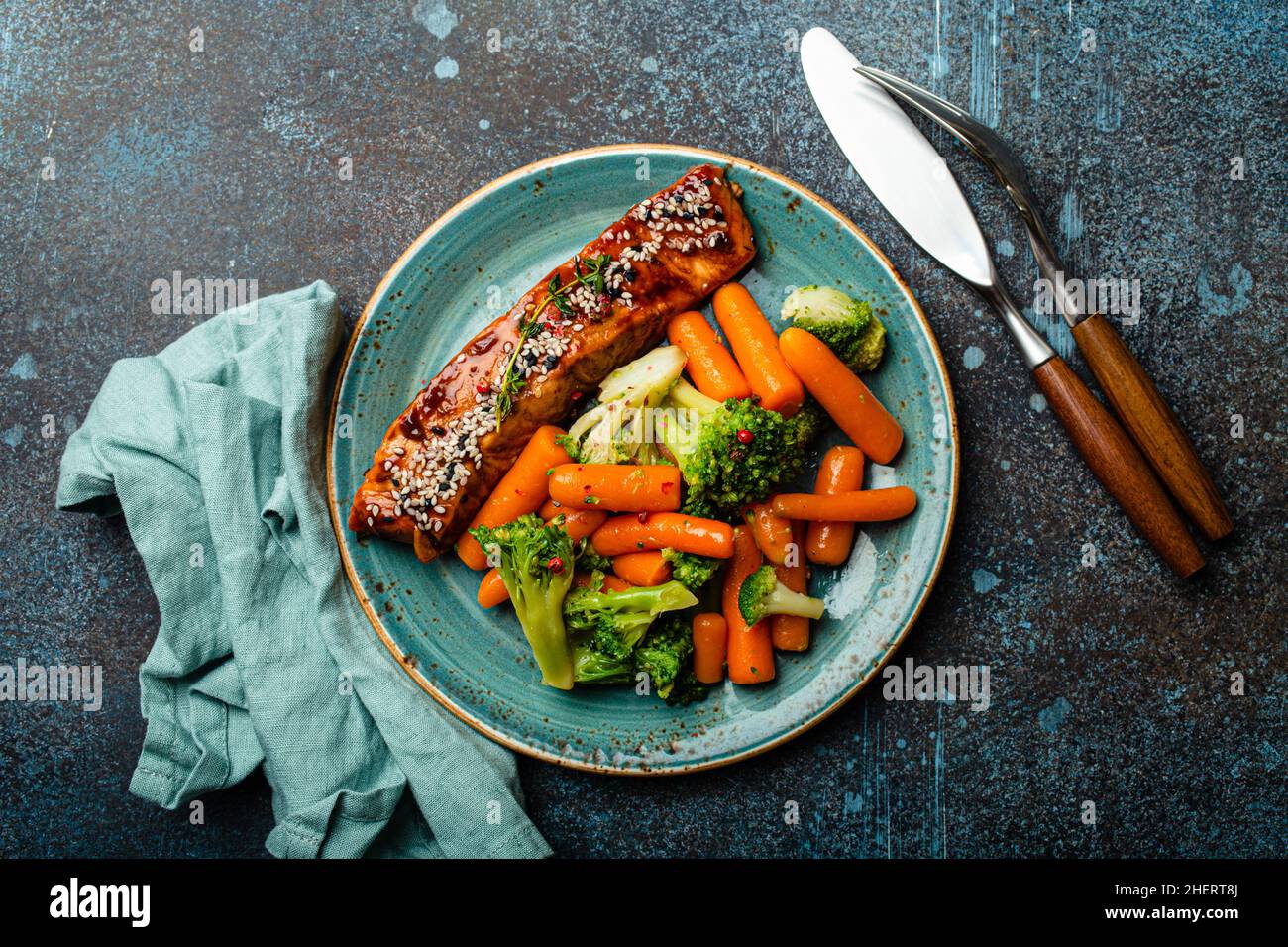 Grilled salmon fillet steak in teriyaki sauce with roasted vegetables carrot and broccoli Stock Photo