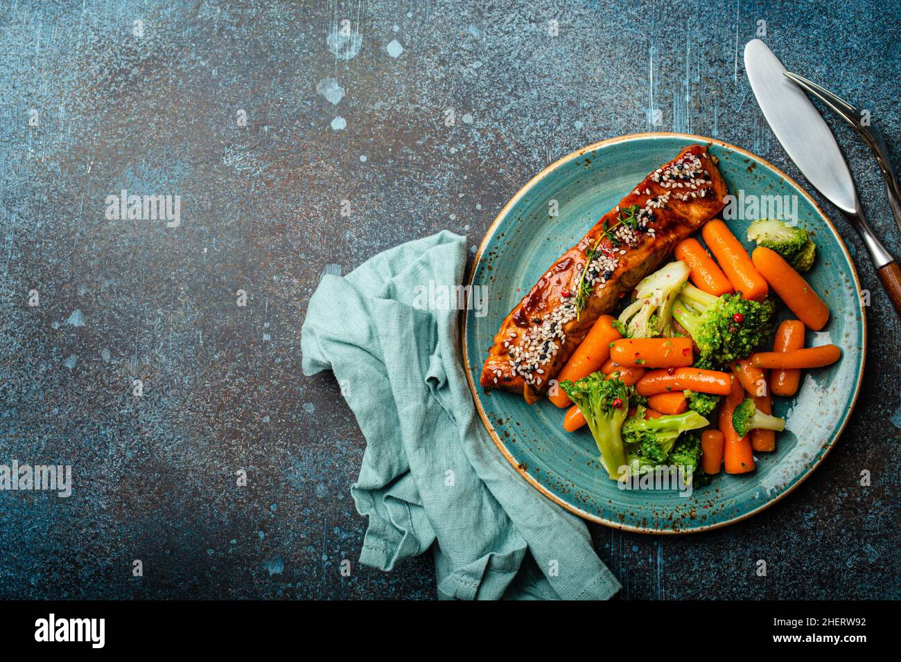 Grilled salmon fillet steak in teriyaki sauce with roasted vegetables carrot and broccoli Stock Photo