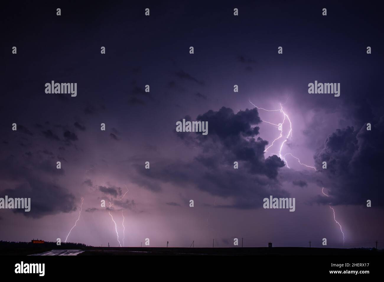 Lightning bolt strike from a thunderstorm with storm clouds Stock Photo