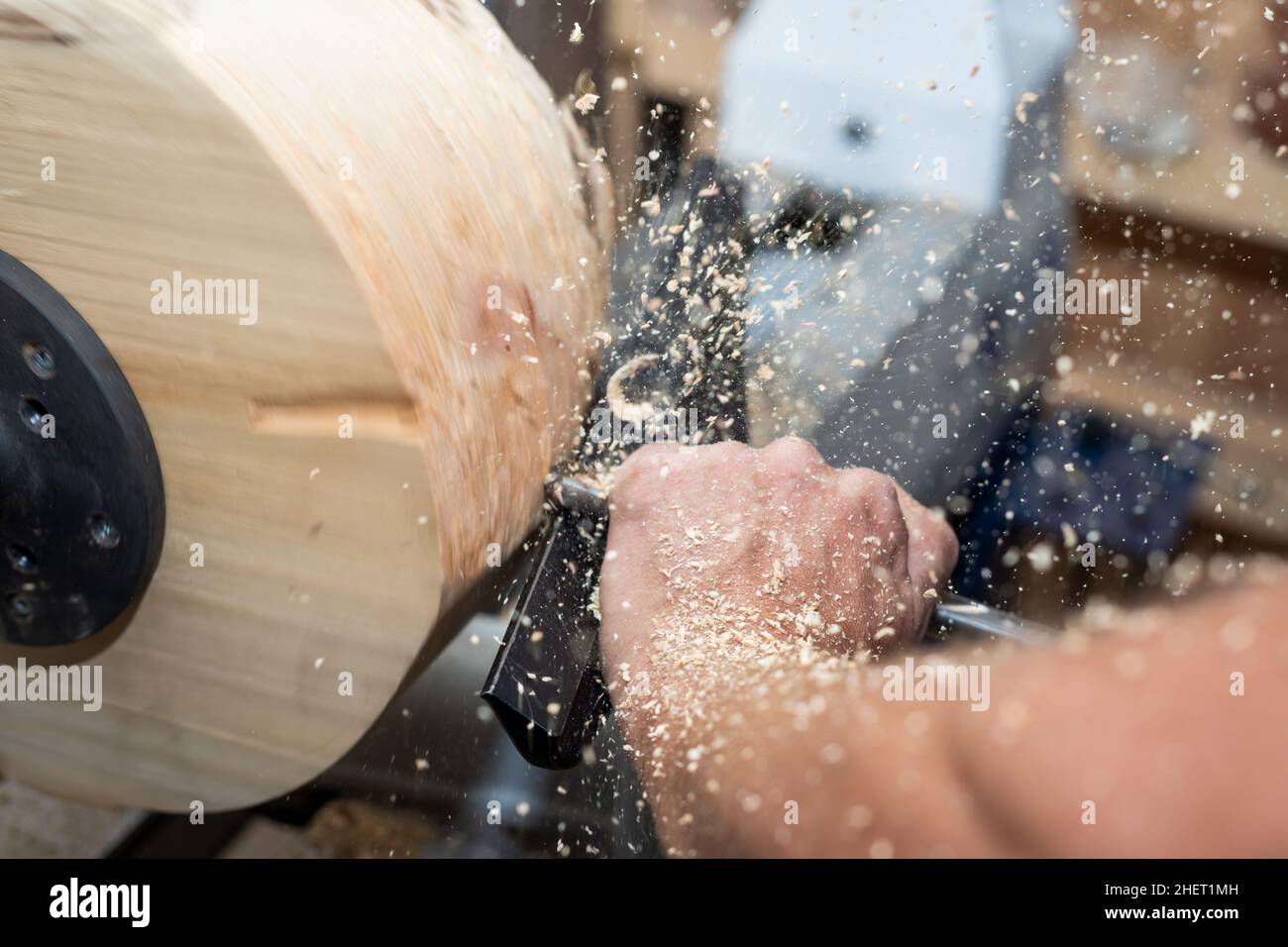 shavings and sawdust flying around while wood turnery for a bowl Stock Photo