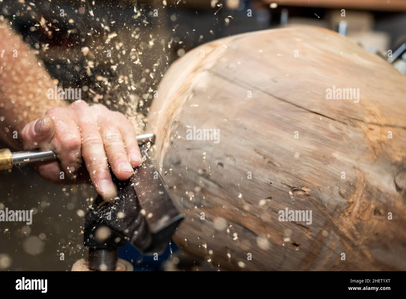 piece of timber rotates to create wooden bowl with turnery machine Stock Photo