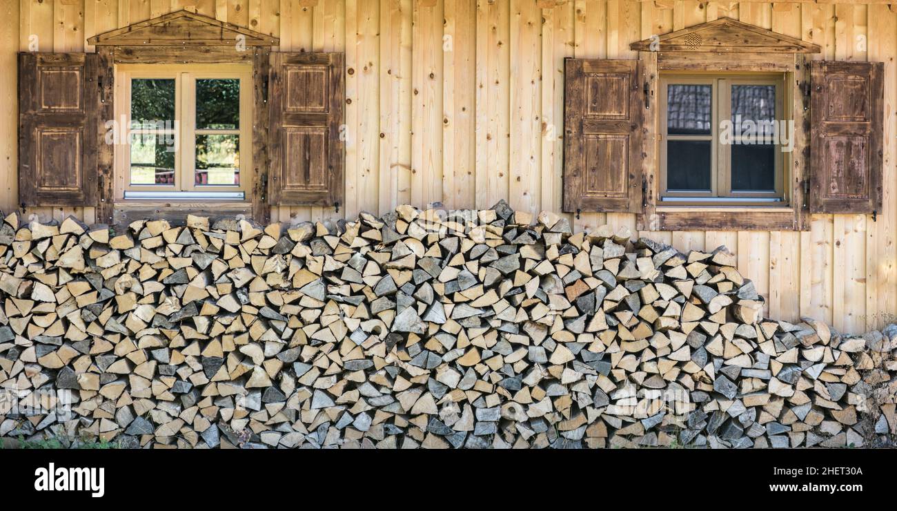 front view of wooden chalet house with wood stack and window shutter Stock Photo