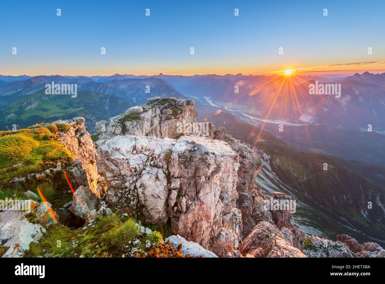 rock with grass on top of tirol mountains at sunset Stock Photo