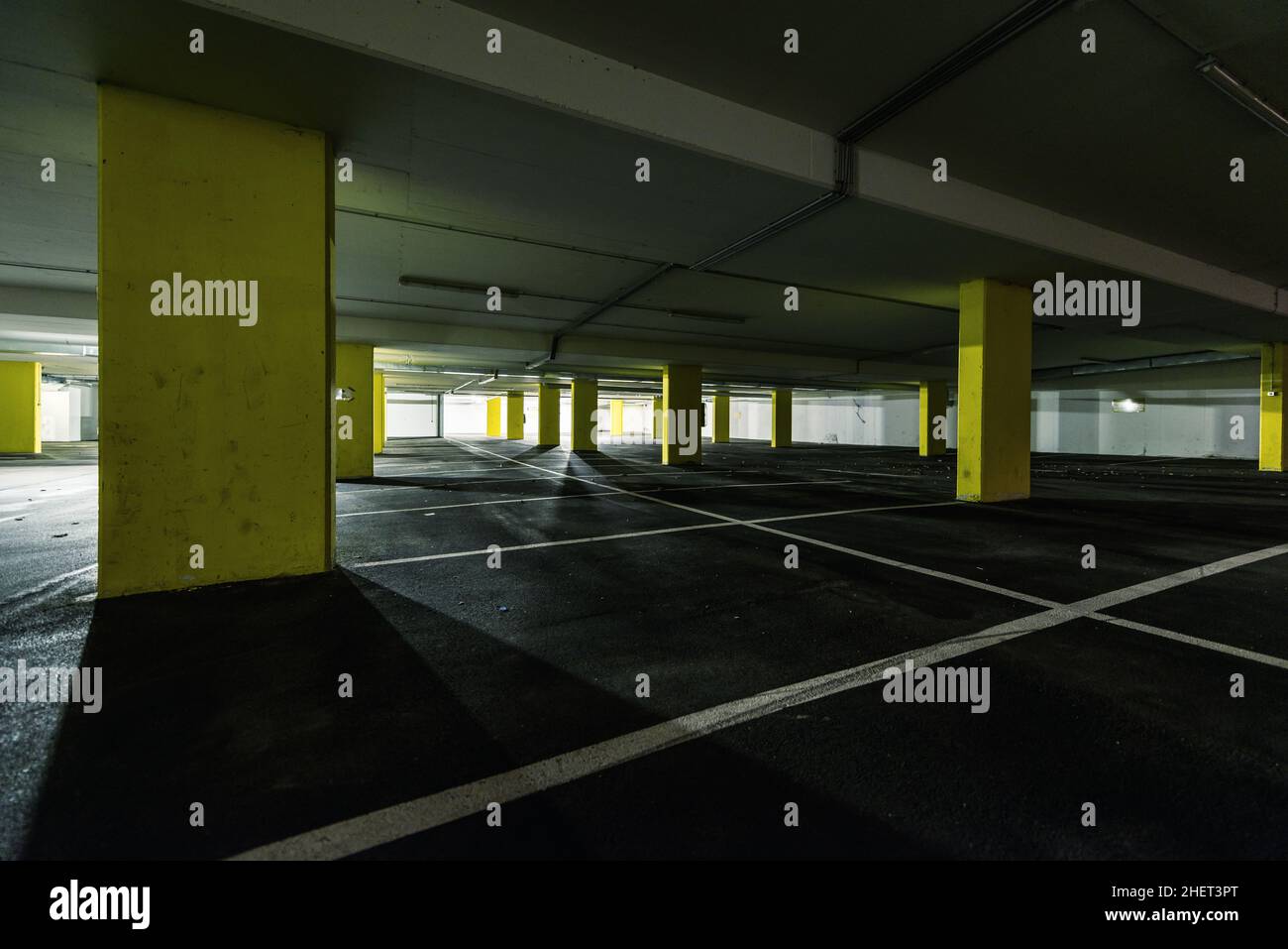 perspective view through yellow columns at underground parking Stock Photo