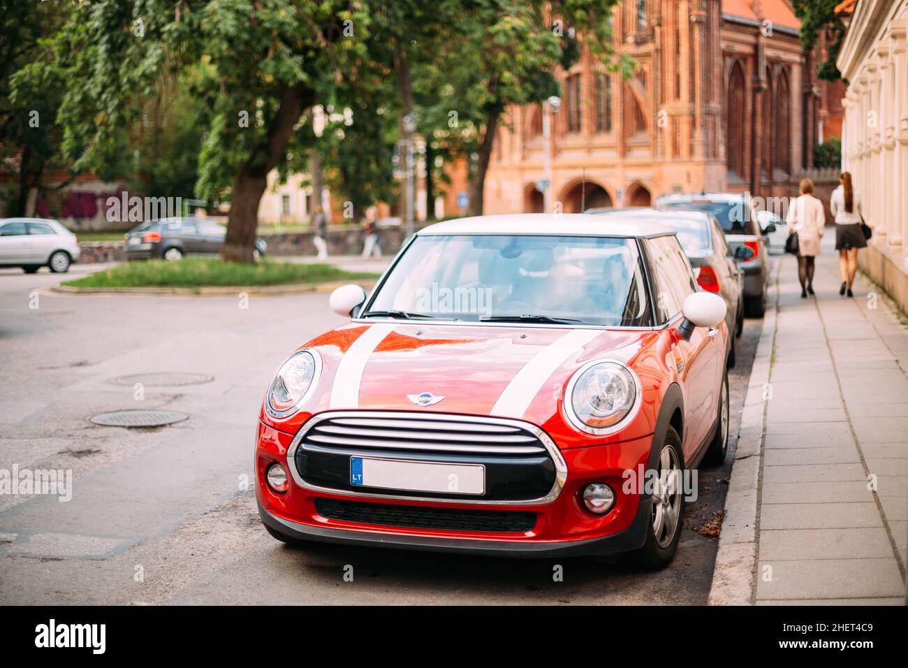 Red Color Car With White Stripes Mini Cooper Parked On Street In Old