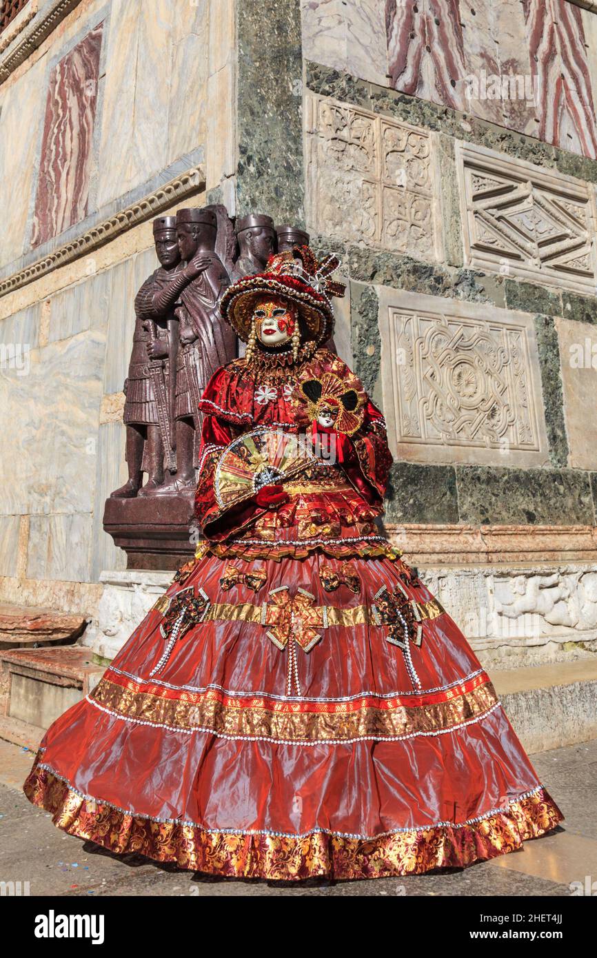 Woman in beautiful historic Venetian fancy dress costume posing at Four Tetrarchs Statues, St Mark's Square, Venice, Carnevale di Venezia, Italy Stock Photo