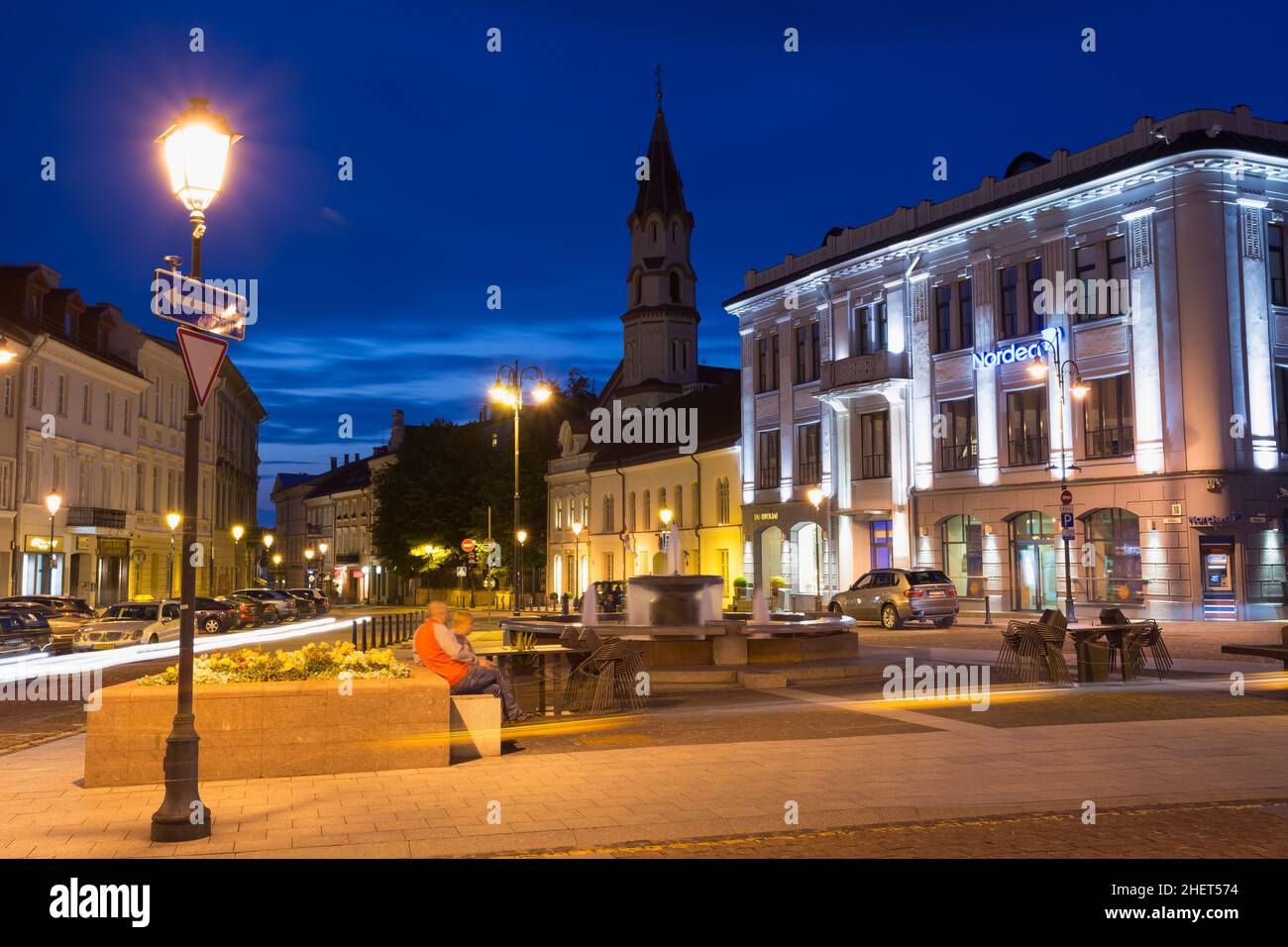 Vilnius Lithuania. Fountain Between Illuminated Didzioji Street And Rotuses Square, Motion Blur Stock Photo