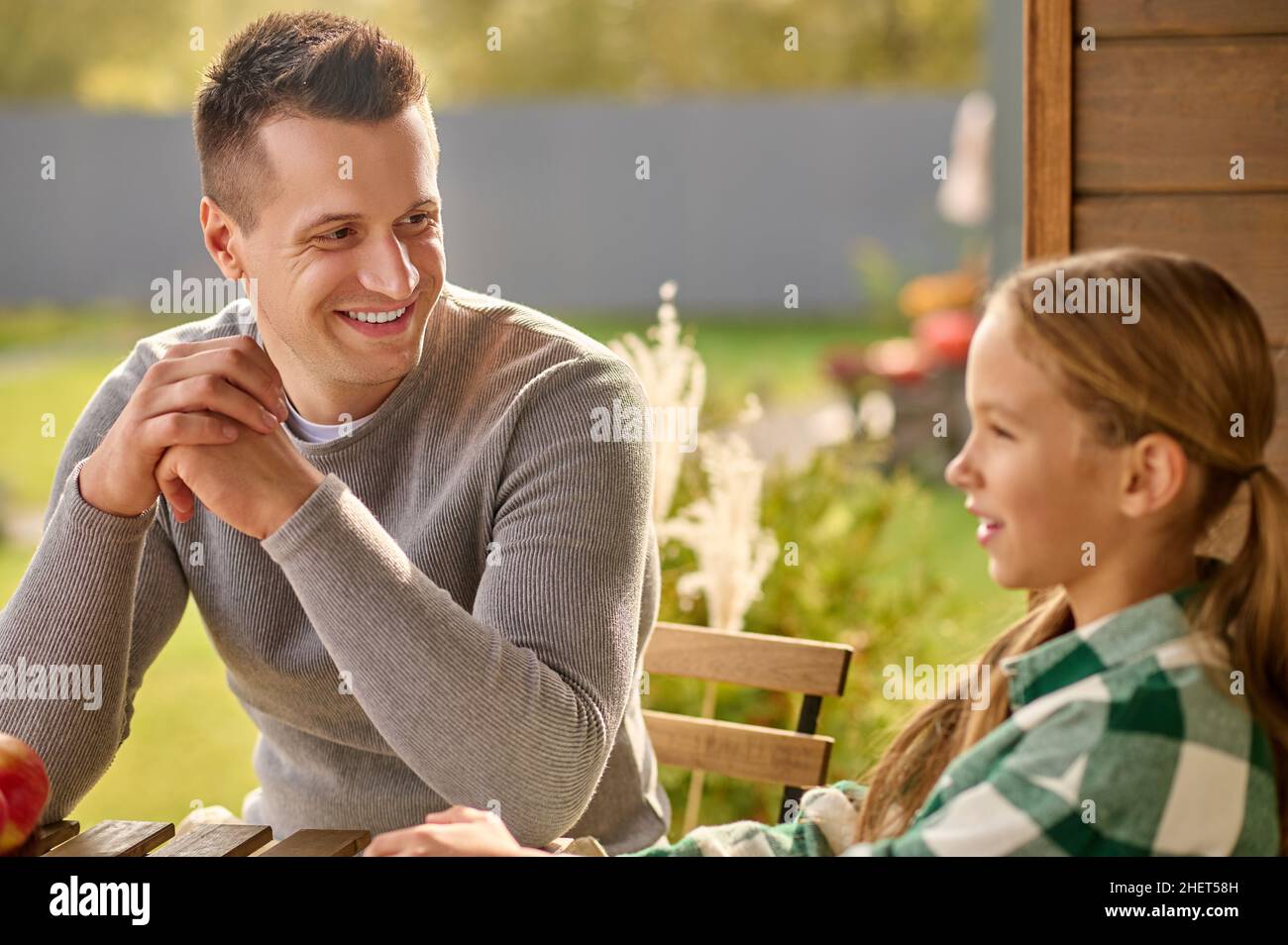 Man looking closely at girl telling story Stock Photo