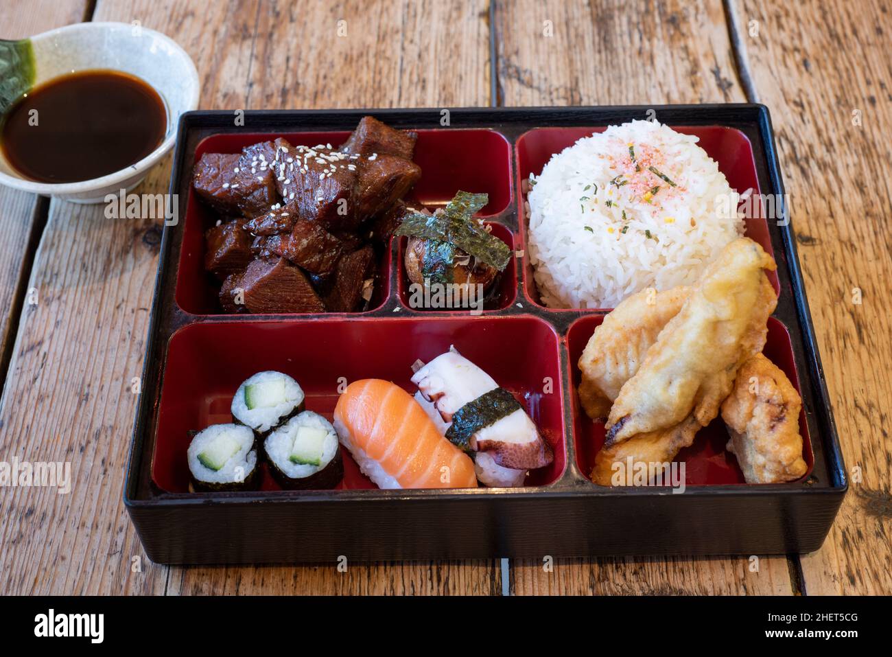 Japanese Asian cuisine : Beef Teriyaki bento box with rice, tempura battered vegetables and salmon and squid sushi nigiri & nori Stock Photo