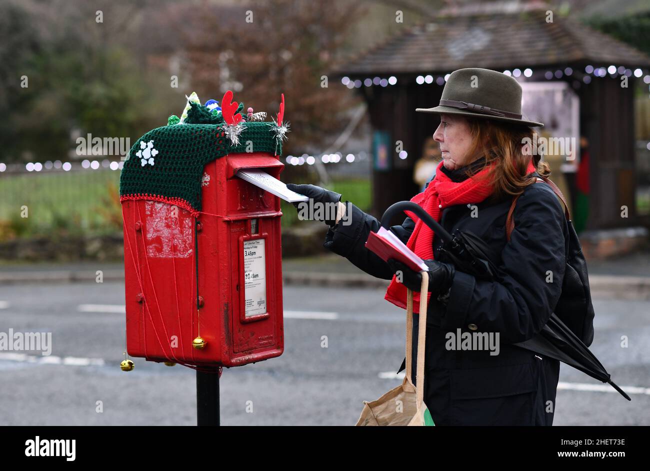Last post for Christmas cards woman posting cards a Xmas decorated mail box in Coalbrookdale, Shropshire, ukl Stock Photo