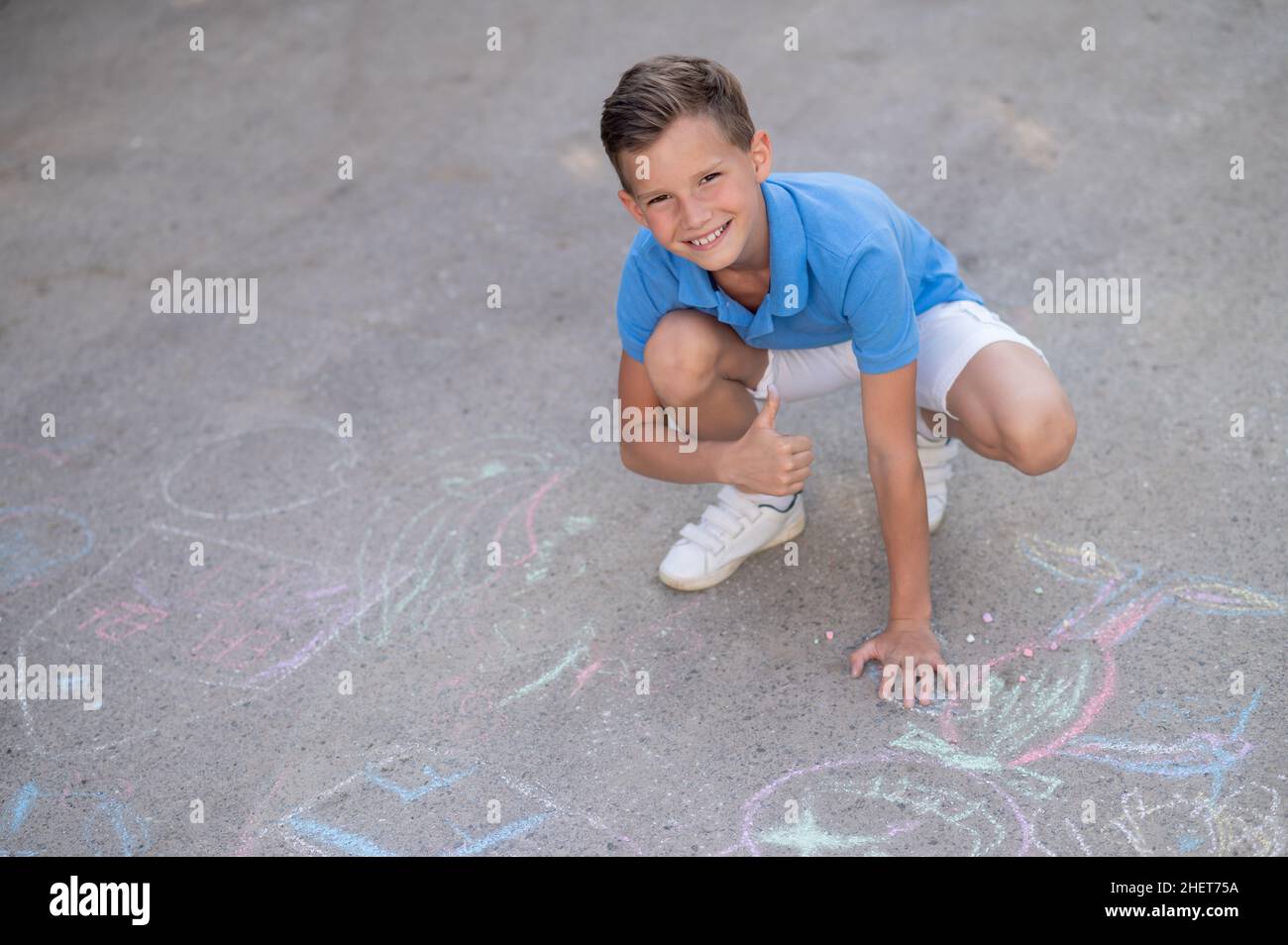 Happy boy approving his chalk drawings on the ground Stock Photo Alamy