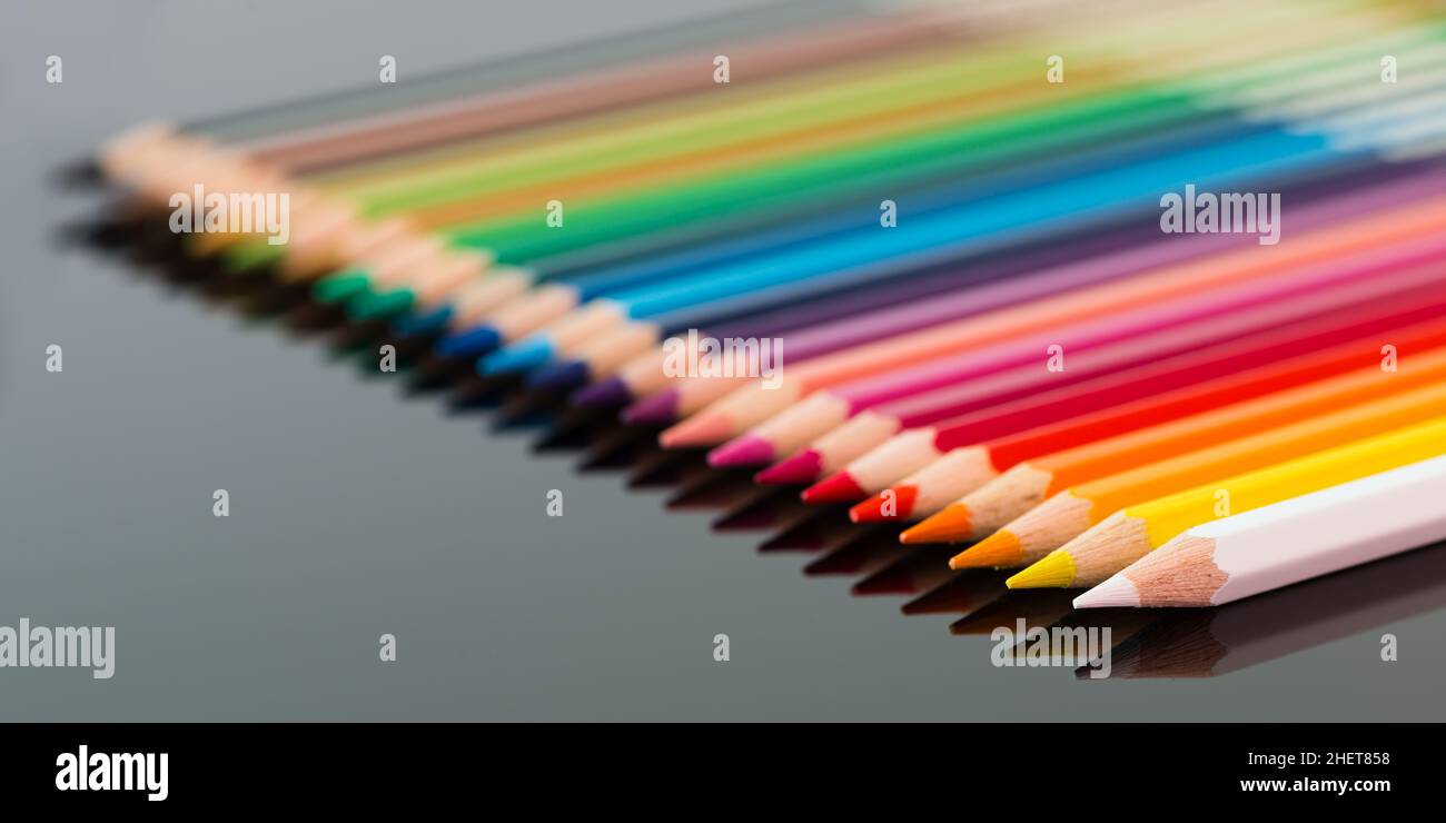 arranged colored wood pencils lying on black background Stock Photo