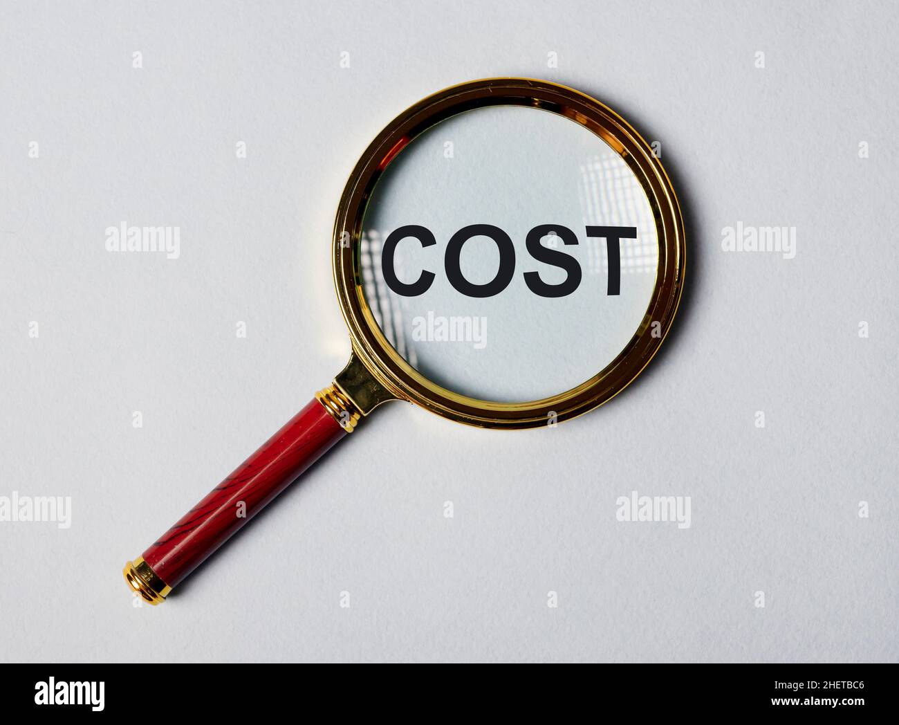 Cost word through magnifying lens on background Stock Photo Alamy