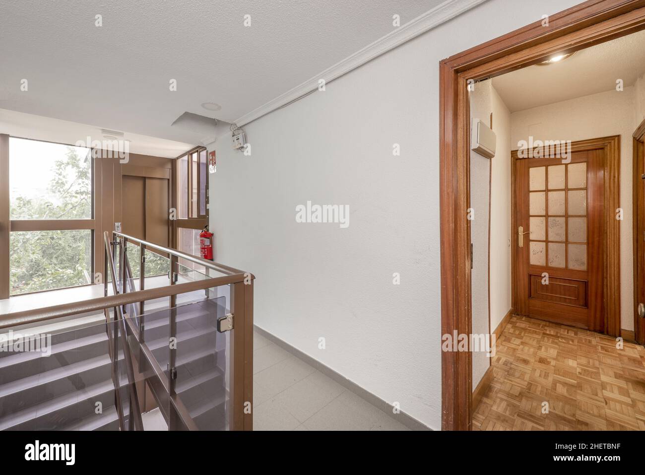 Entrance to a residential house with dark wood carpentry, stairs with aluminum and glass balustrade Stock Photo