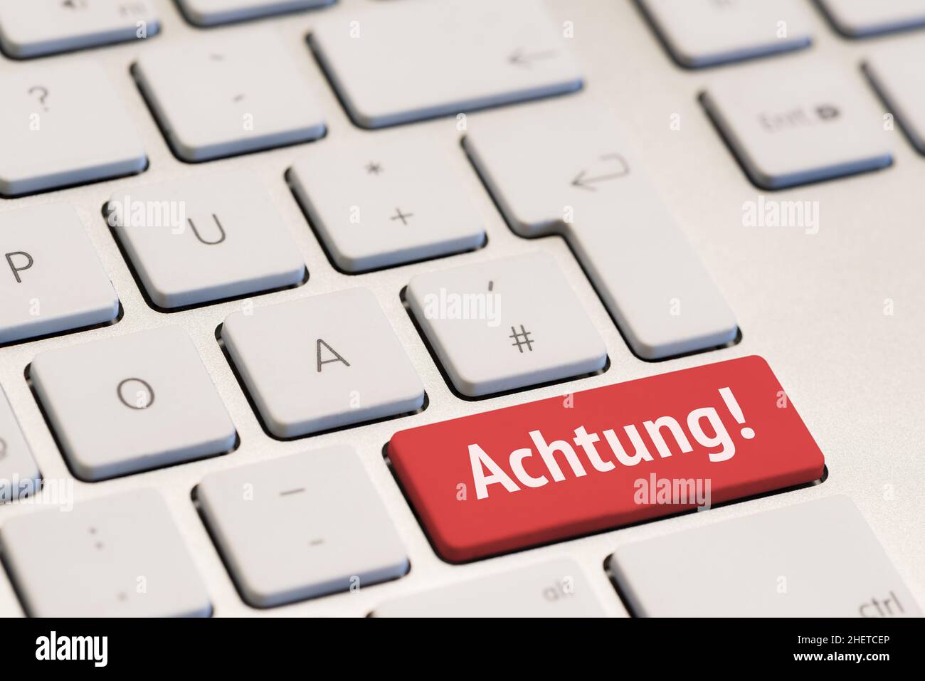 computer keyboard with the word achtung on red key Stock Photo