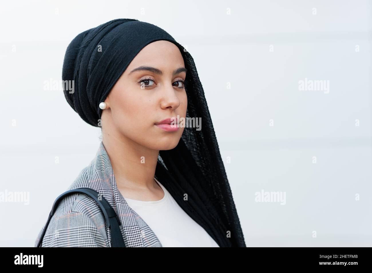 Portrait of a muslim adult woman wearing a black headscarf looking at camera in the park Stock Photo