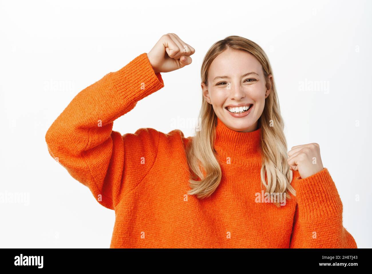 Cheerful blond girl winning, achieve goal, celebrating and triumphing