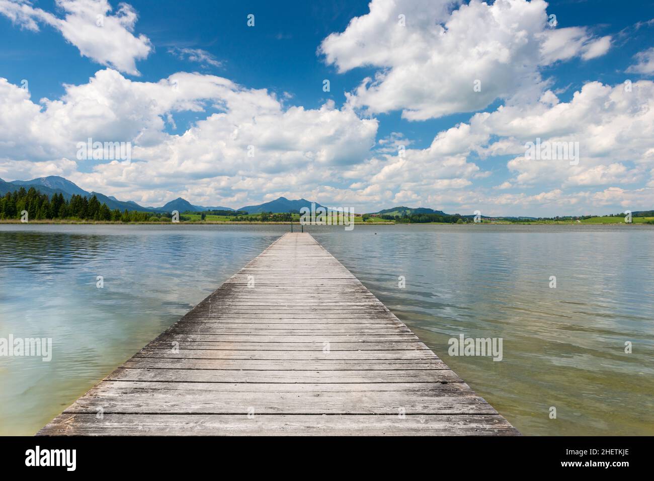 wooden boardwalk at swim lake hopfen with blue sky in spring Stock Photo