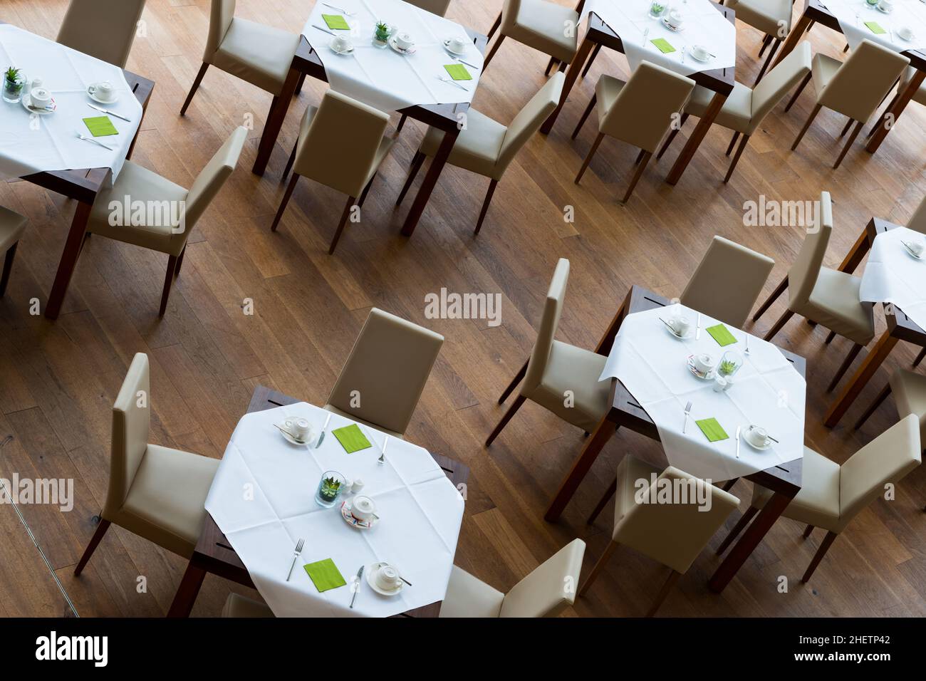 decorated tables and leather chairsn arranged on wooden floor Stock Photo