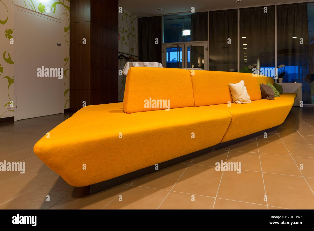 perspective of huge yellow orange sofa in hotel lobby Stock Photo