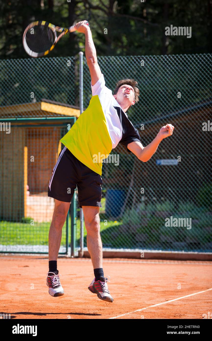 tennis player hits ball on highest point to serve Stock Photo Alamy